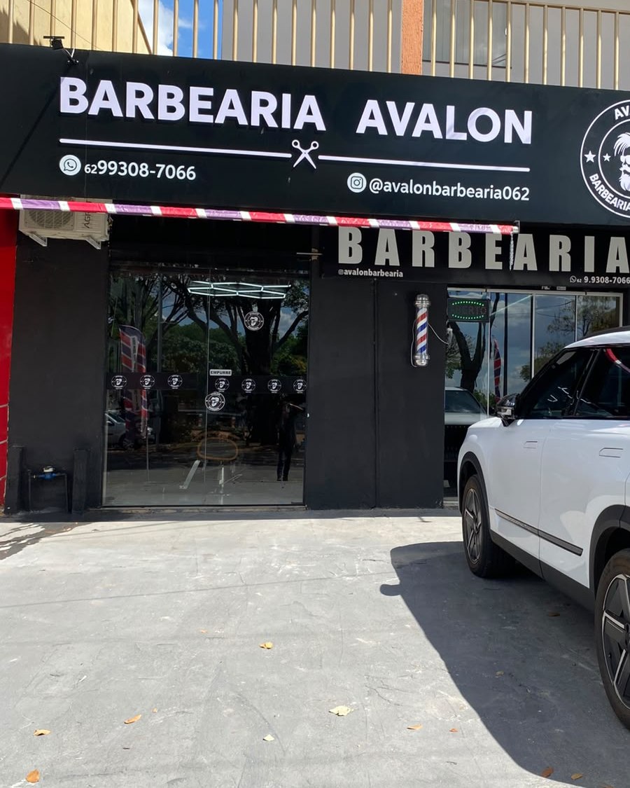Barbeiro da Avalon finalizando o corte de um cliente, ambos sorrindo